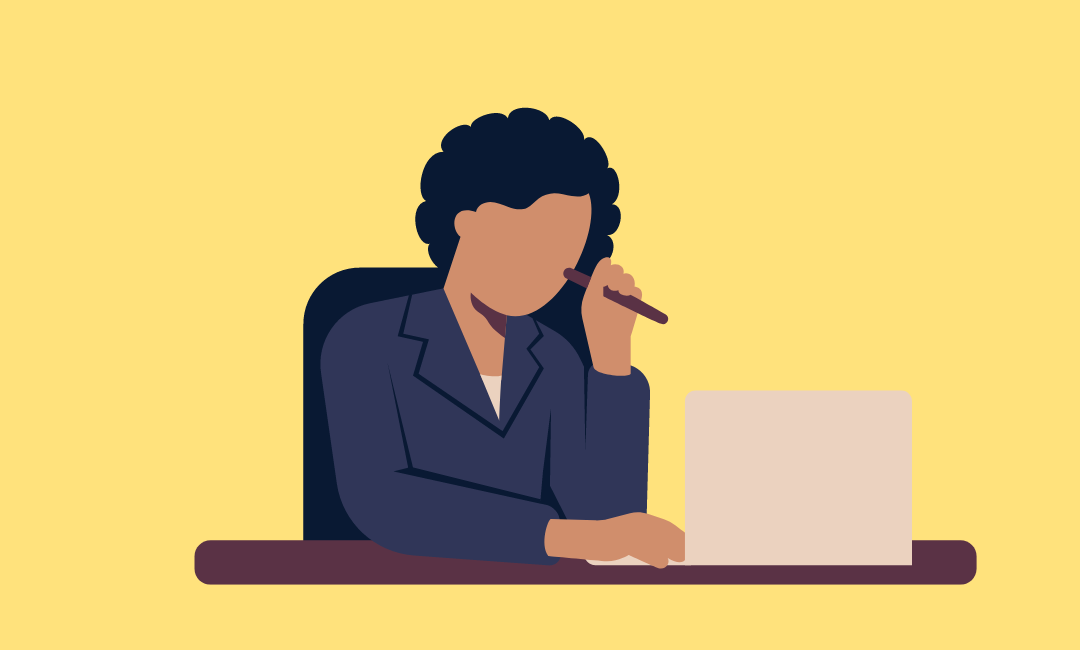 A cartoon image of a woman sitting at a desk wearing a navy business jacket. She is sitting at a desk looking at a computer, with a  pen in one hand which she is holding up near her face. The cartoon does not have facial features.