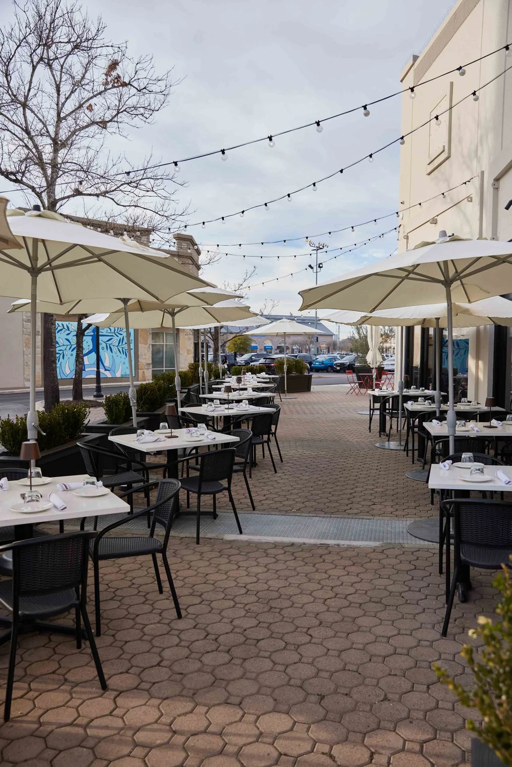 Piatti patio at Alamo Quarry Market with umbrellas and bistro lighting