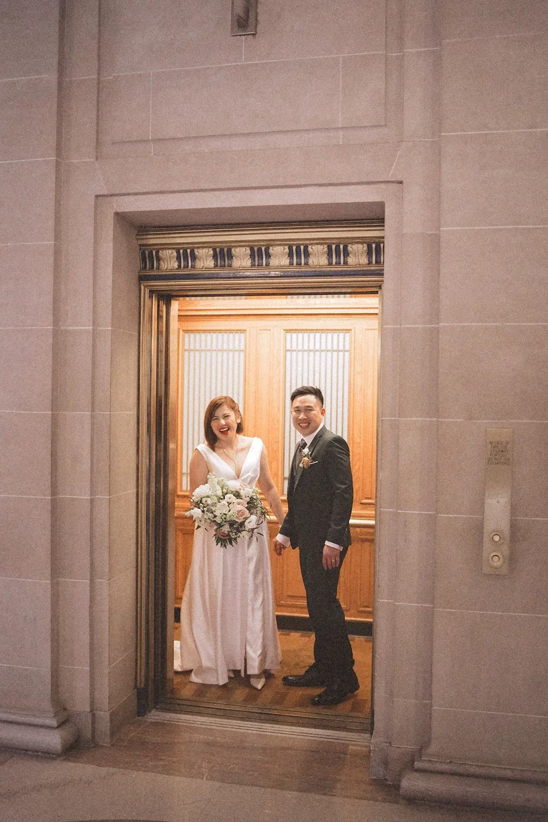 Couple smiling in elevator, captured by san francisco elopement photographer​