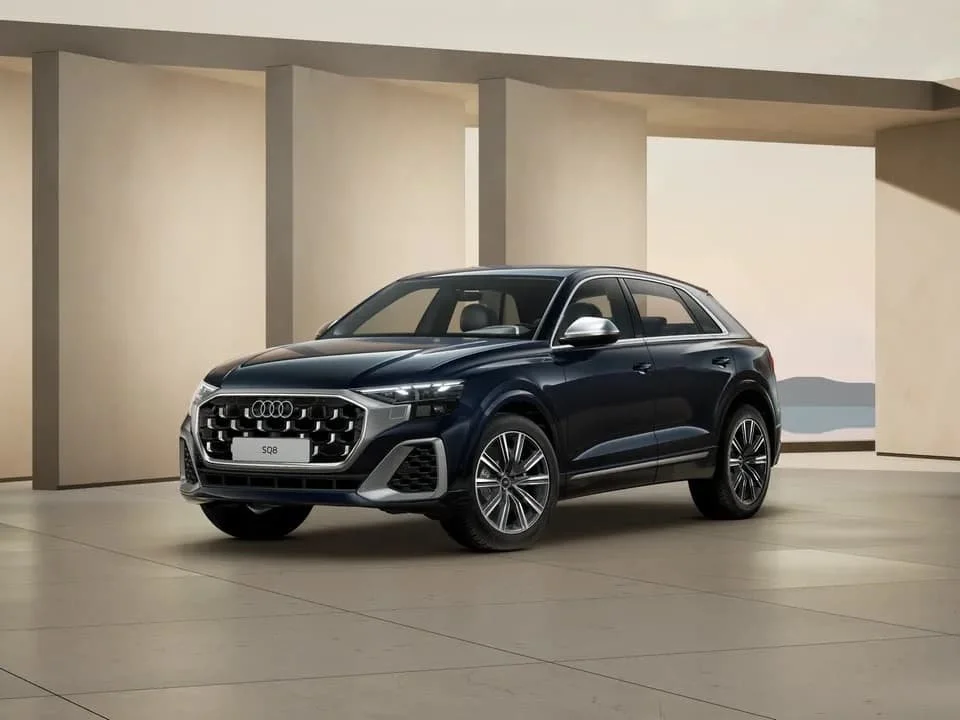 Schwarzer Audi SQ8 SUV in einem modernen, minimalistischen Raum mit hellen Wänden und einem Blick auf Wasser im Hintergrund.