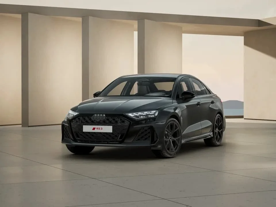 Schwarzer Audi RS3 Limousine in einem modernen, minimalistischen Raum.