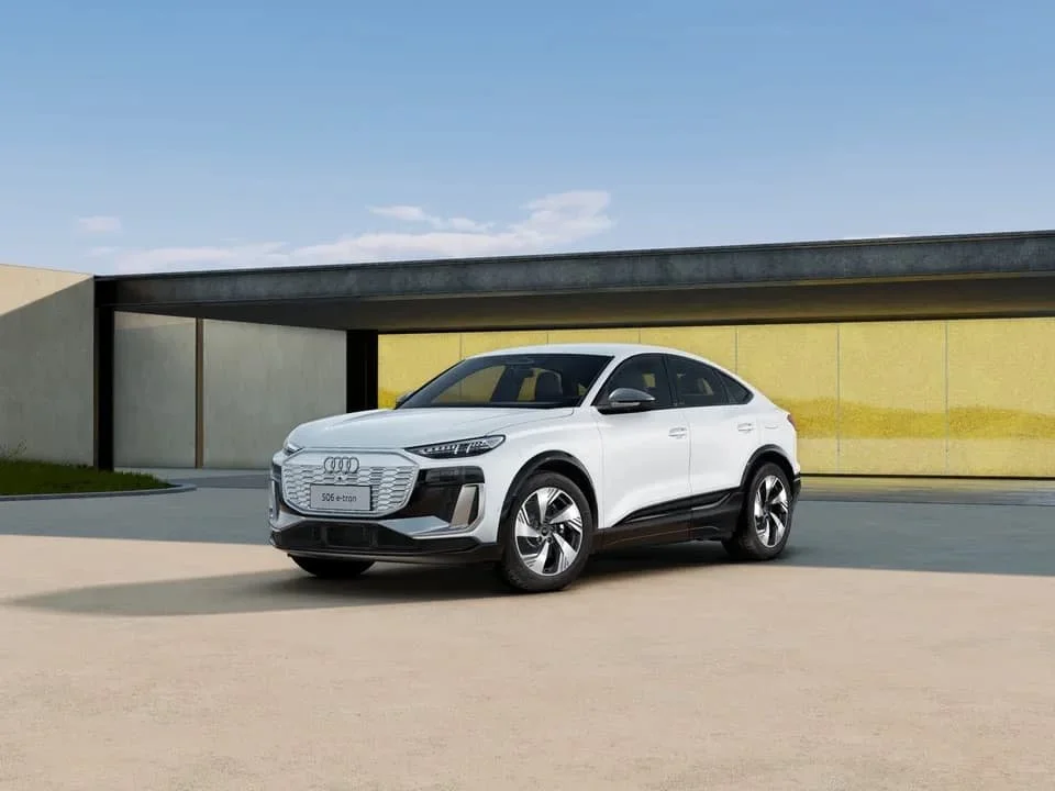 Weißer Audi SUV vor moderner Gebäudefassade im Freien