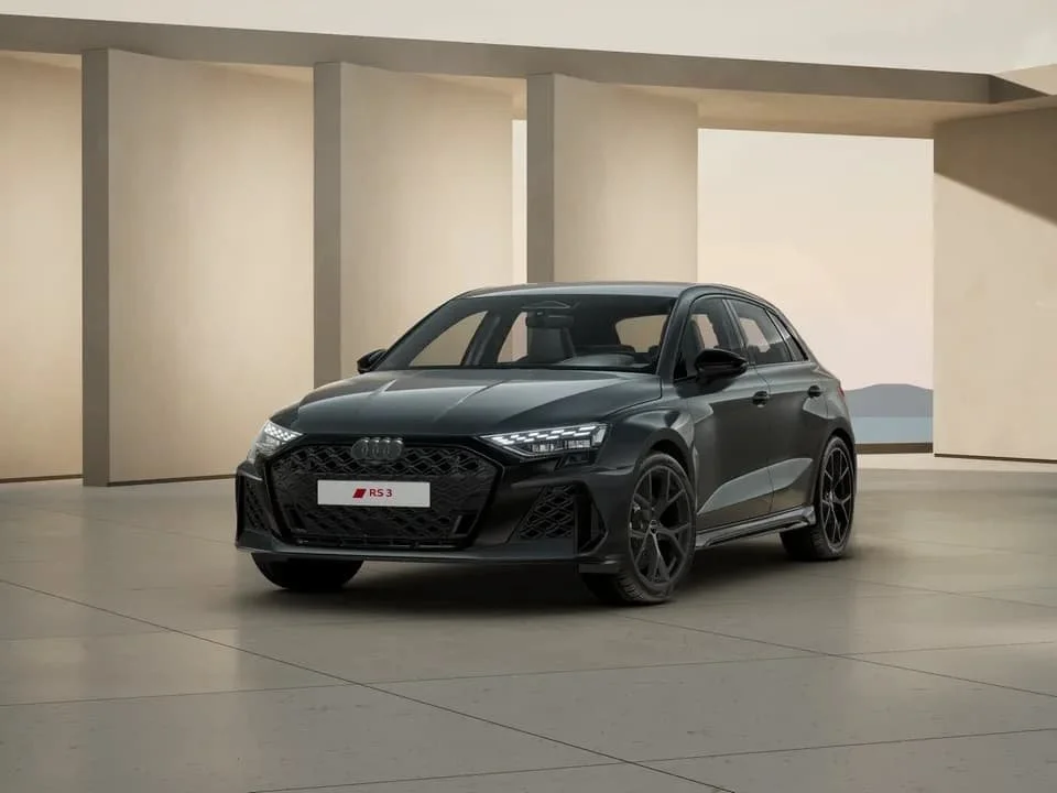 Schwarzer Audi RS3 in einem modernen Ausstellungsraum.