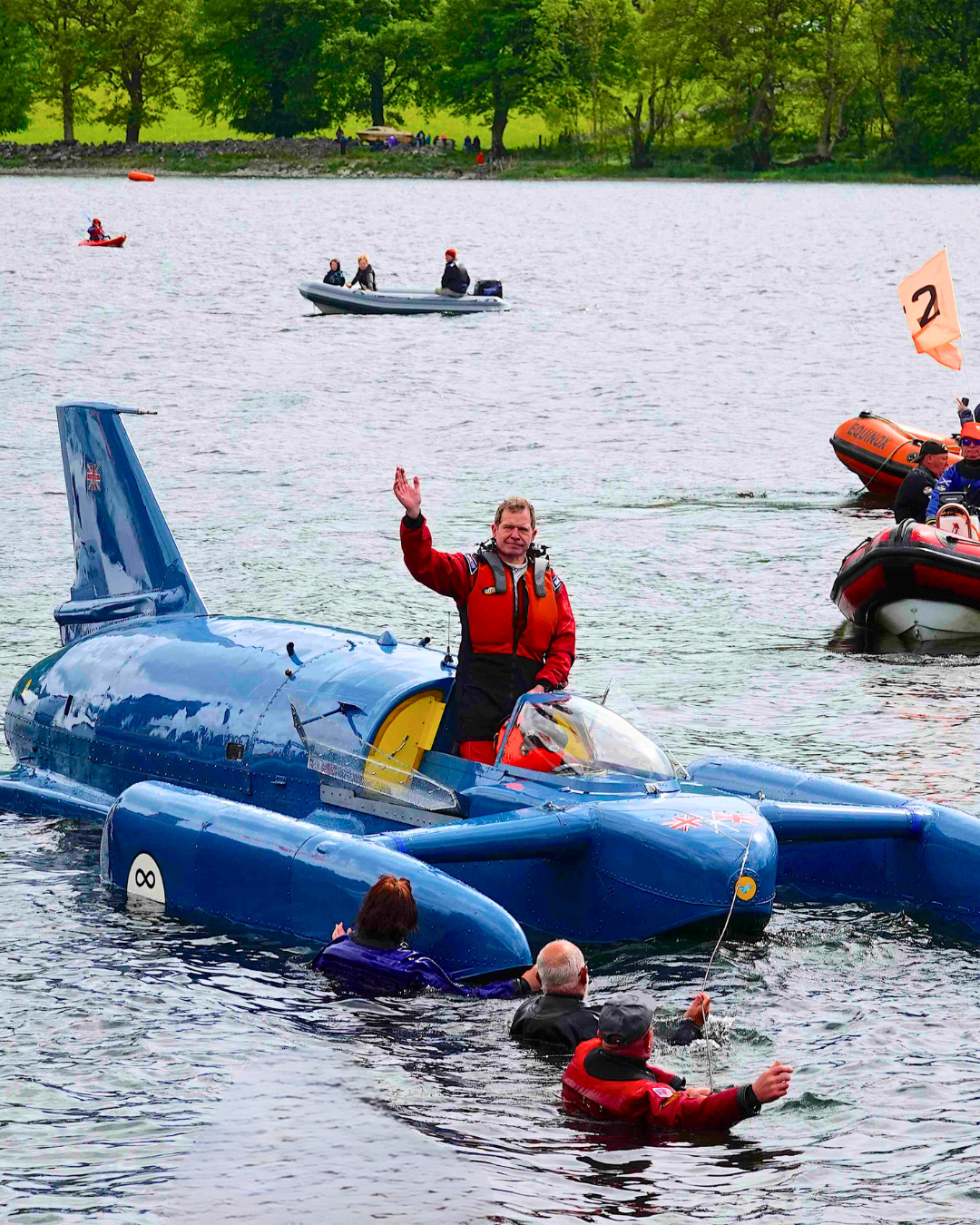 The pilot of the Bluebird waving in the lake
