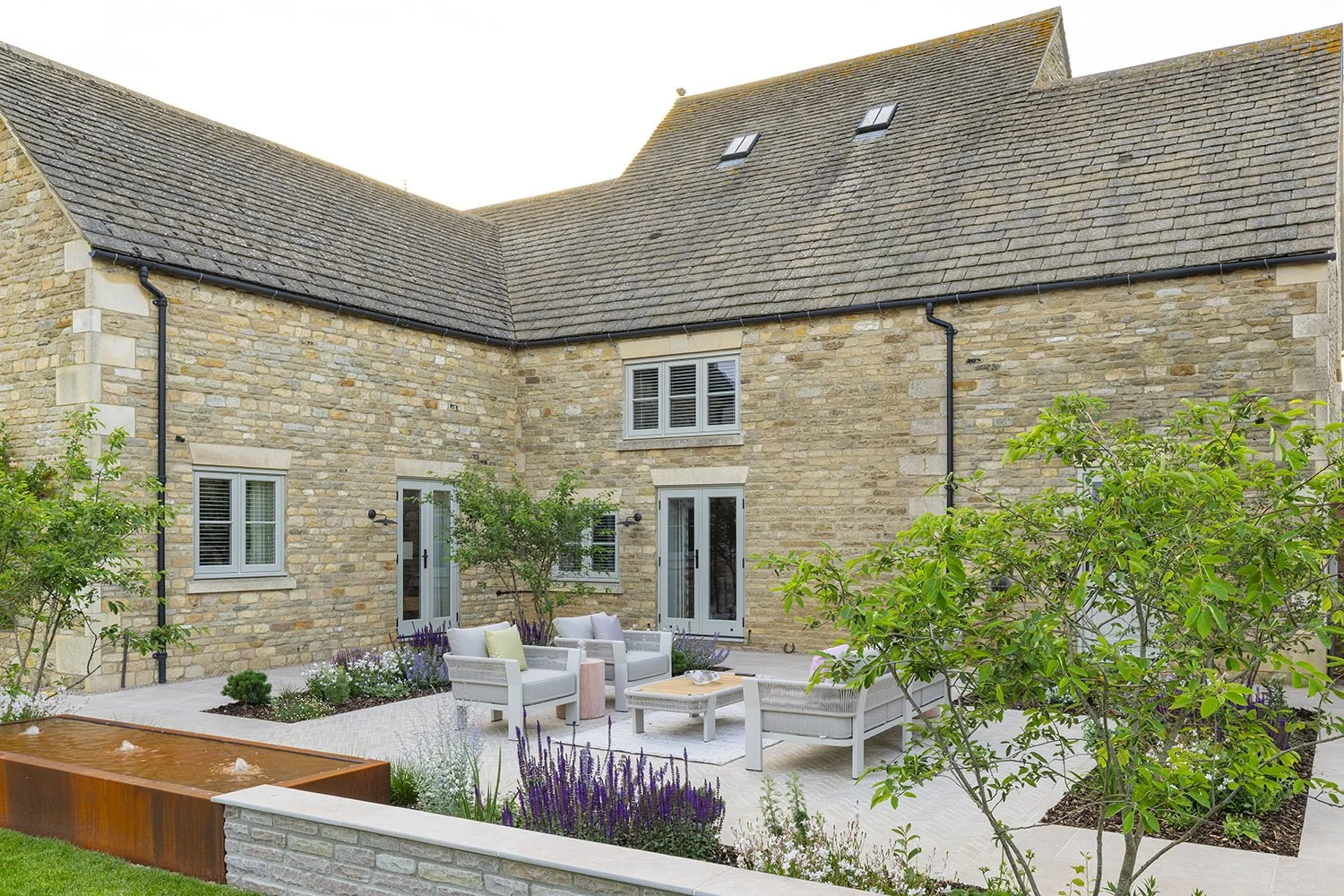 robert-johnson-garden-design-Lincs-herringbone-stone-paving-seating-outdoor-sofa-water-feature.jpg