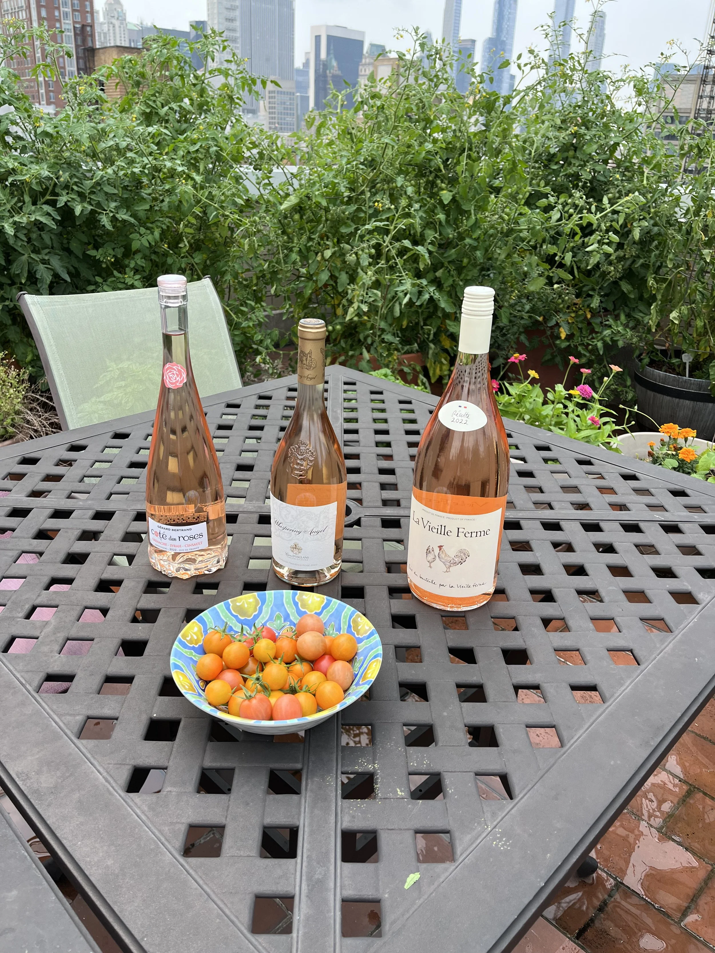 3 bottles rosé wine on table with orange cherry tomatoes