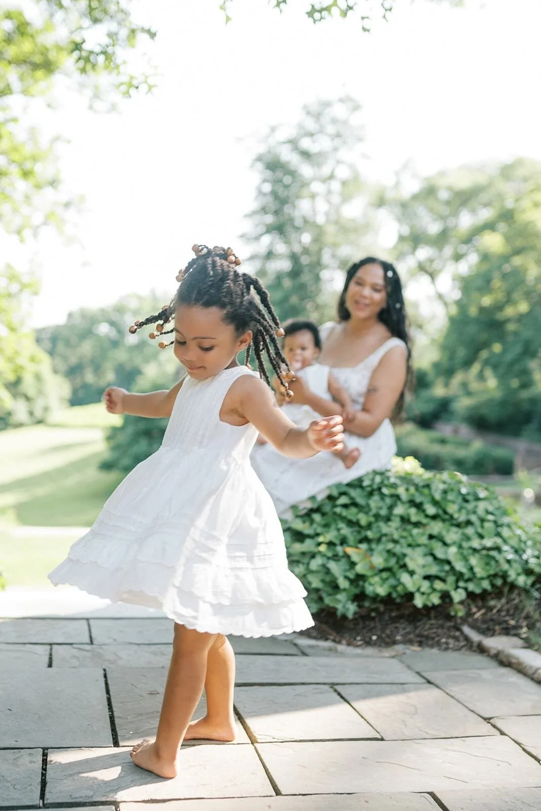 Daughter twirling while Mom holds baby and watches - Raleigh Newborn Photographer