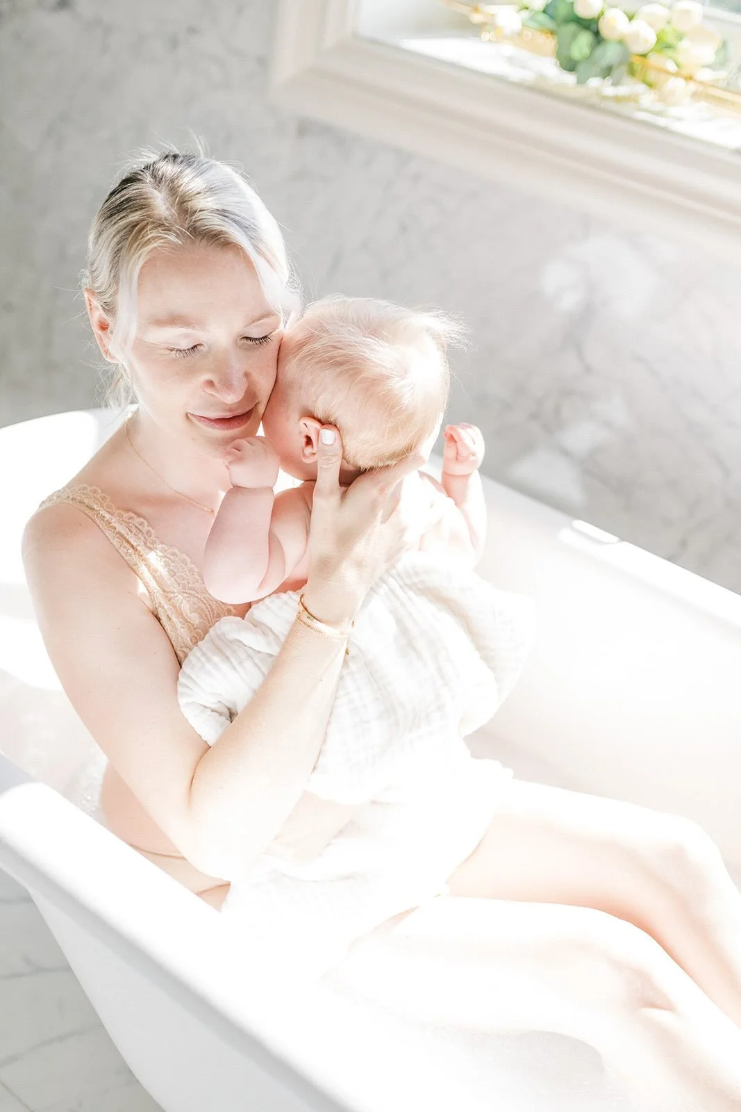 Mother holding baby in the bathtub in the natural light - Raleigh Newborn Photographer