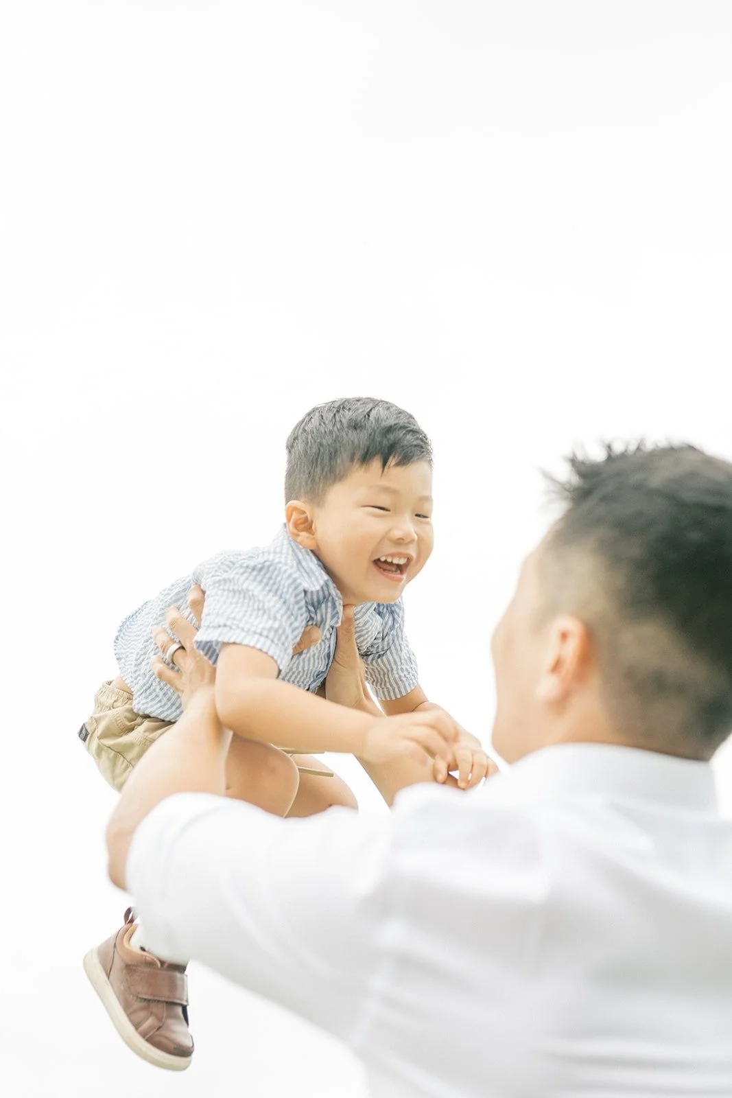 Dad holding up son in the natural light outside - Raleigh Family Photographer