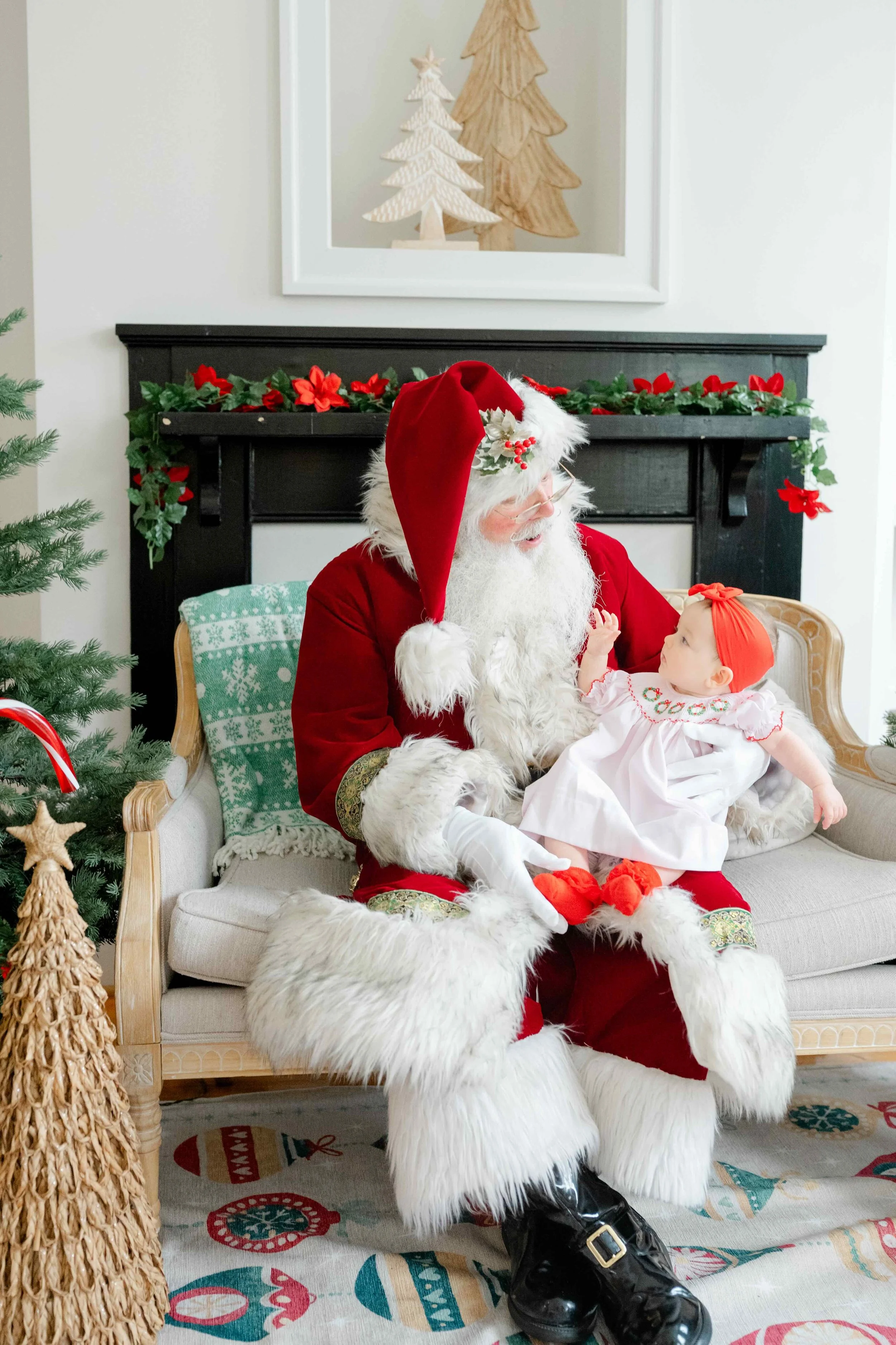 Little girl sitting in Santa's lap while she touches his beard in awe during her Santa photos in Raleigh, NC with Kelly Bullock Photography.