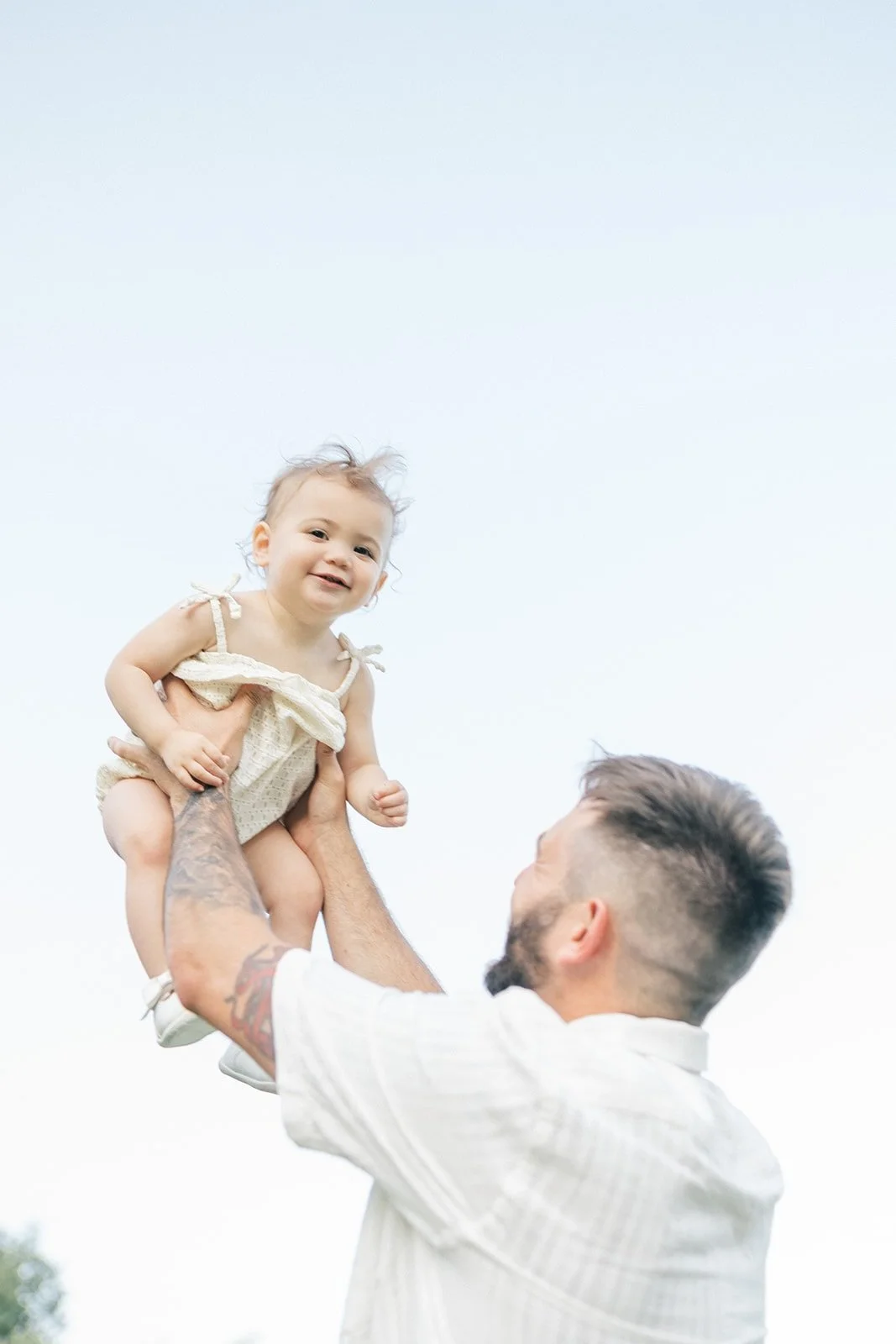 Dad lifting up baby in the air outside - Raleigh Newborn Photographer