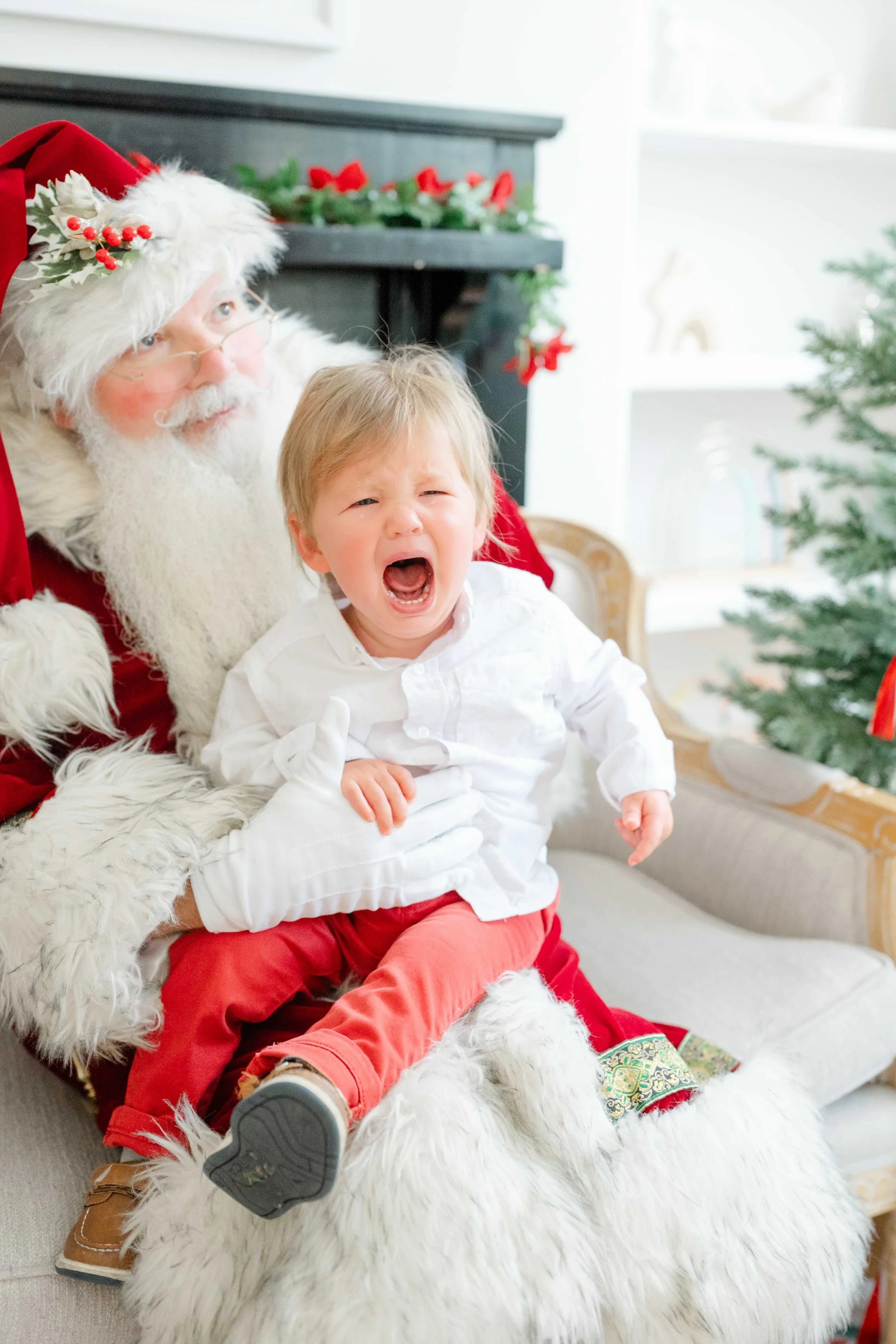 Little boy crying in Santa's lap during his photos with Santa by Kelly Bullock Photography.