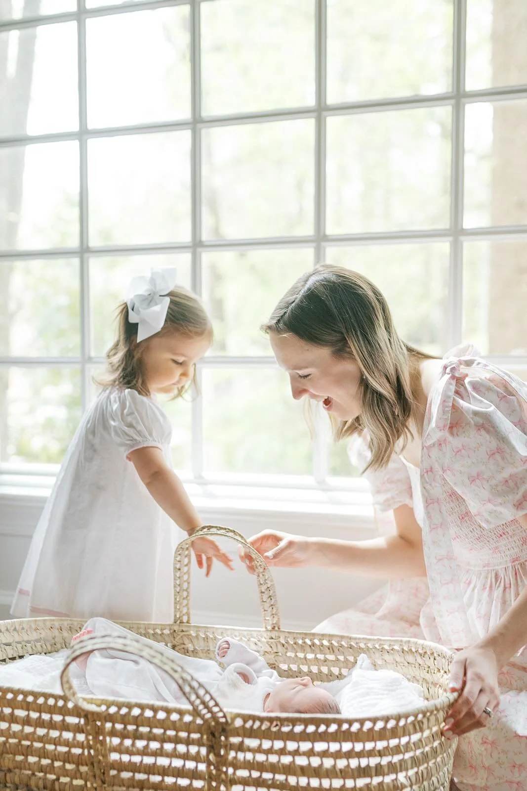 Mother and sister looking at baby in the bassinet - Raleigh Newborn Photographer