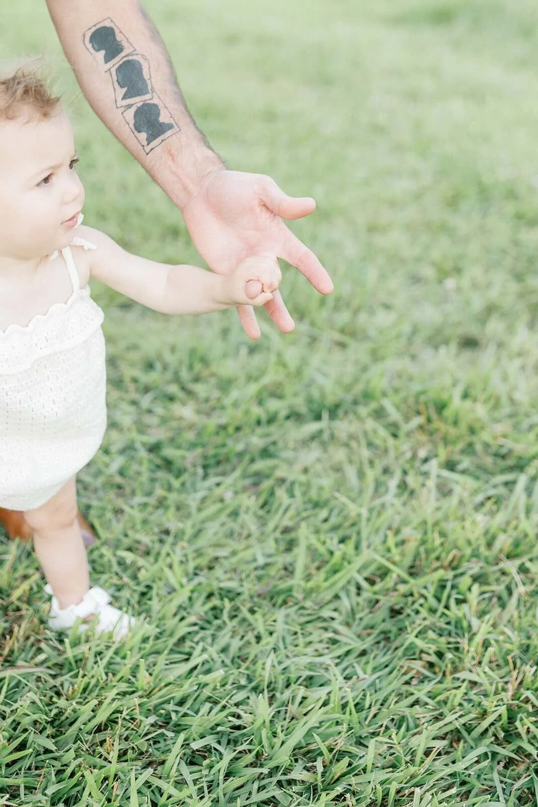 Dad holding baby's hand while walking - Raleigh Newborn Photographer