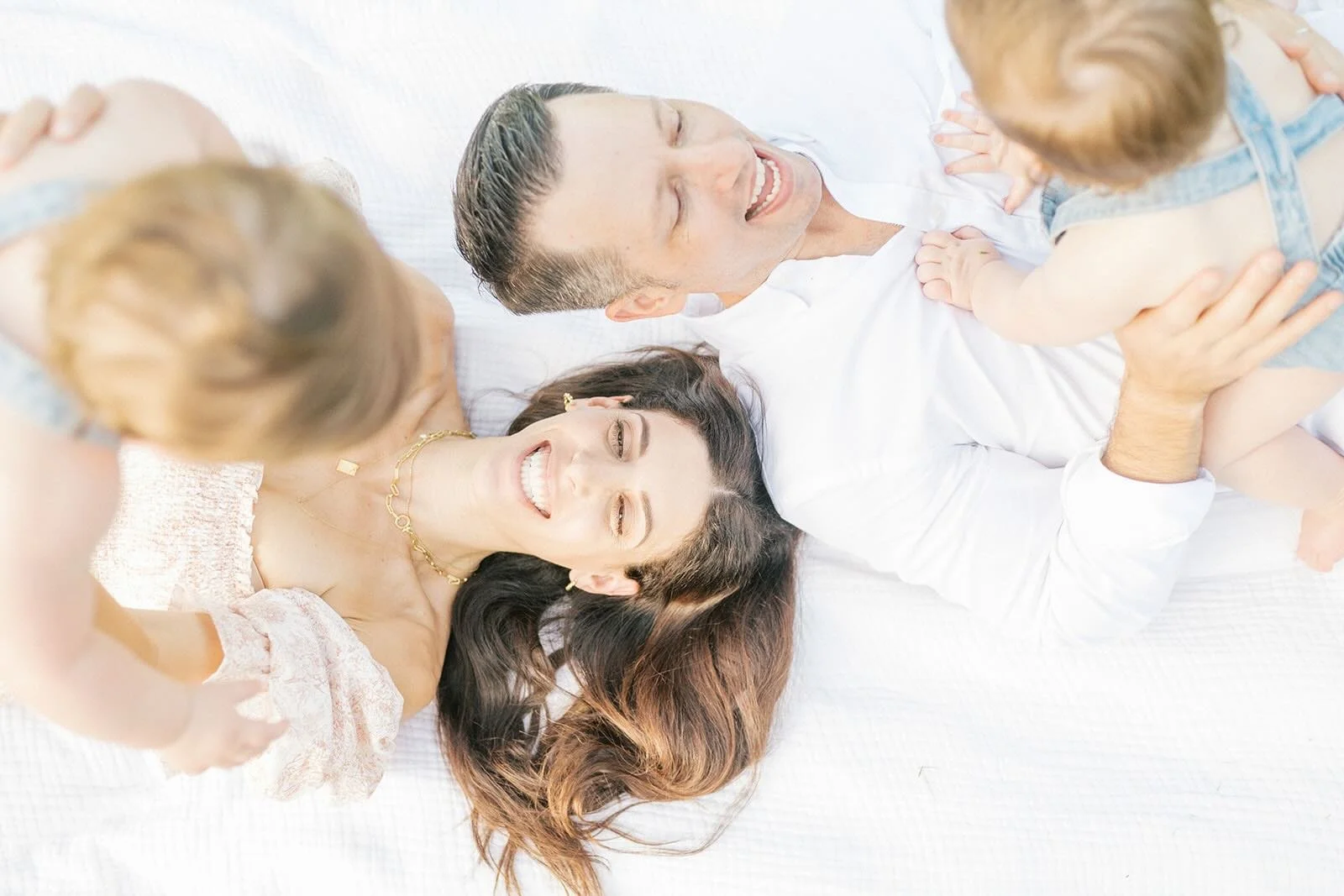 Mom and Dad holding their sons while laying on a blanket outside - Raleigh Newborn Photographer