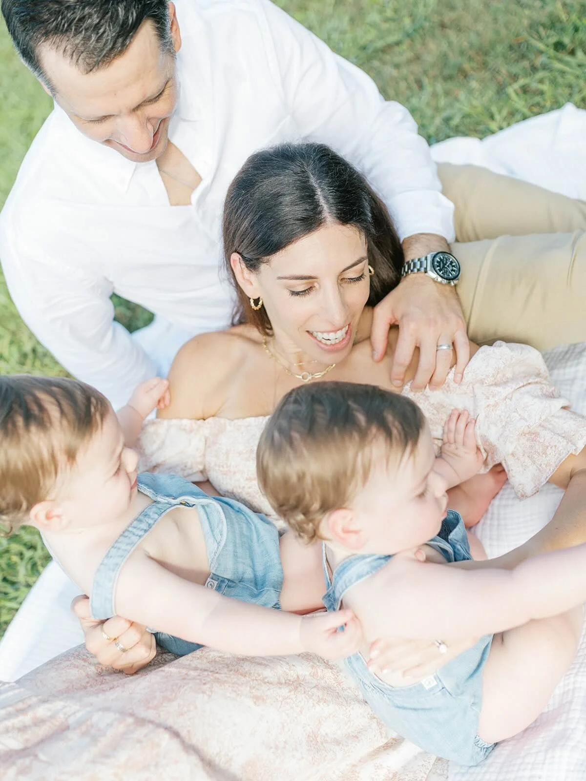 Family cuddles outside on a blanket - Raleigh Newborn Photographer
