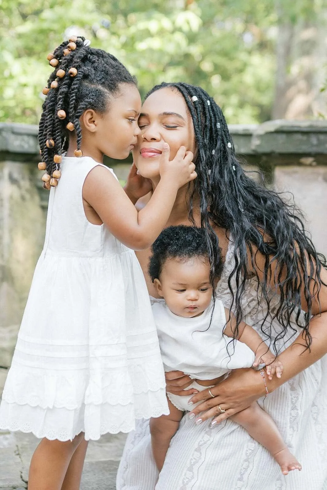Daughter giving mother kisses while holding baby - Raleigh Newborn Photographer
