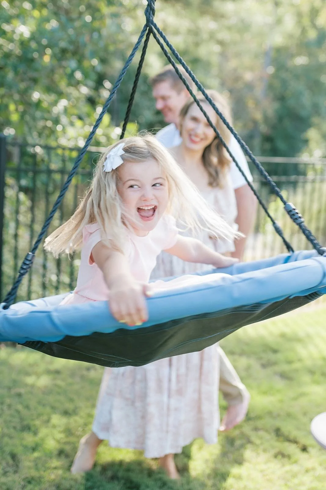 Daughter swimming with Mom and Dad in the background - Raleigh Newborn Photographer