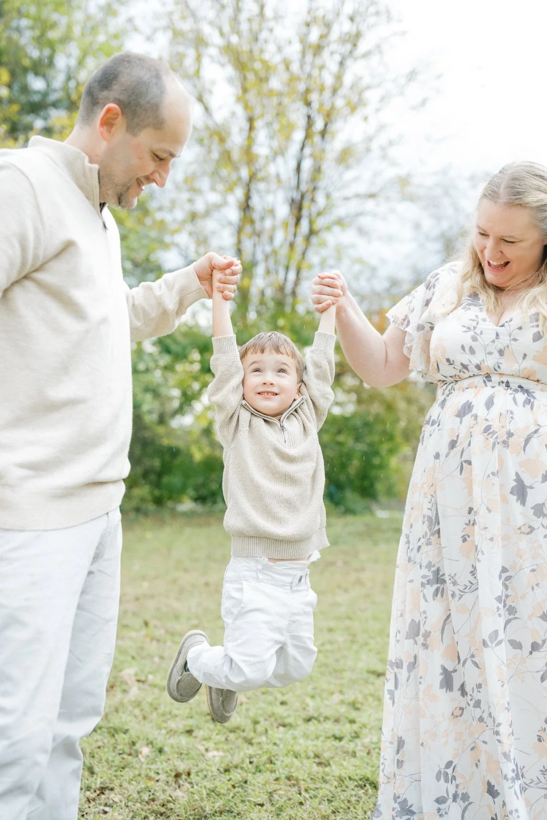 young boy with parents lifting him up during a Raleigh photographer session