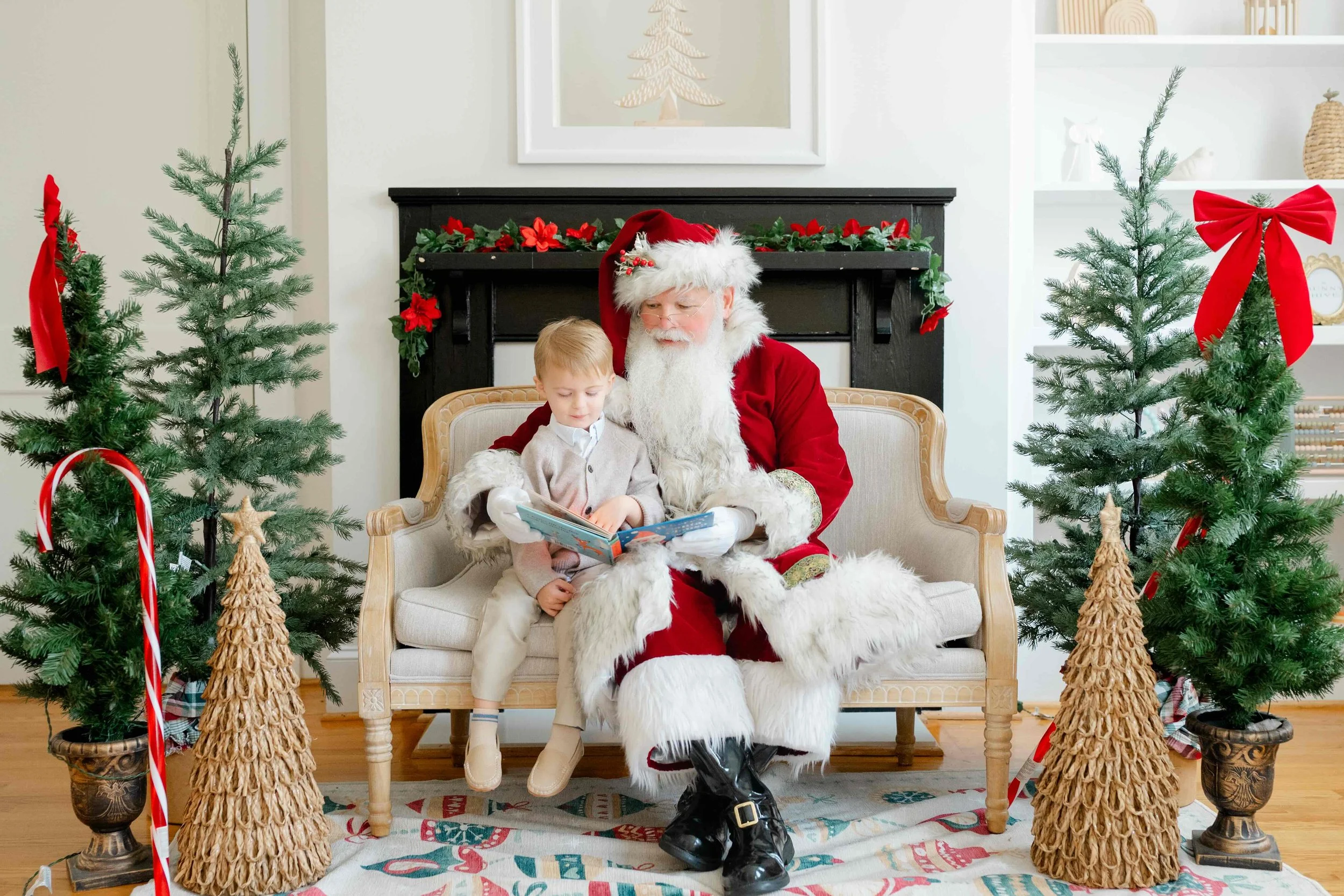 Boy siting next to Santa while reading a book during their family Christmas Activity in Raleigh by Kelly Bullock Photography.