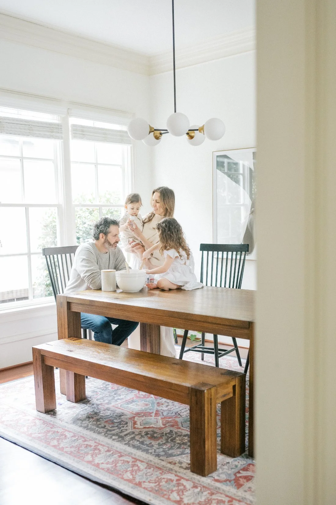 Family gathered around their dining table at home, sharing a joyful everyday moment during a lifestyle photography session.