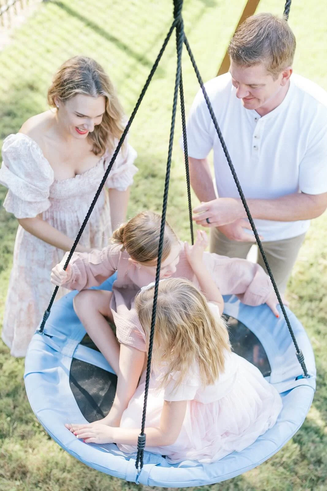 Mom and Dad pushing children on the swings outside - Raleigh Newborn Photographer