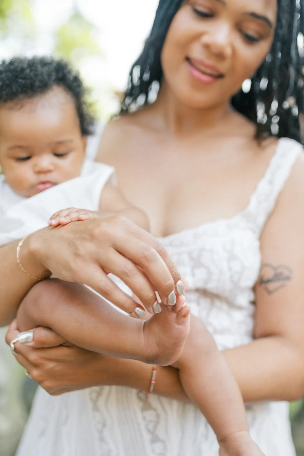 Mom touching baby's feet outside - Raleigh Newborn Photographer