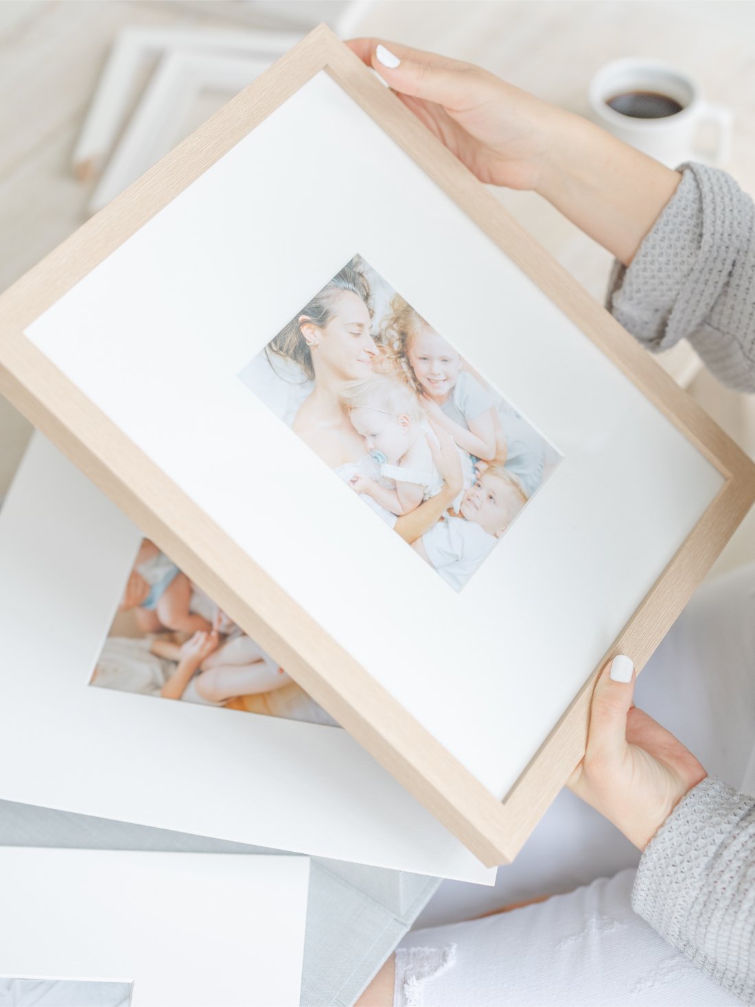 Framed family portrait being held in hands, showcasing printed heirlooms as beautiful Mother’s Day photo gifts.