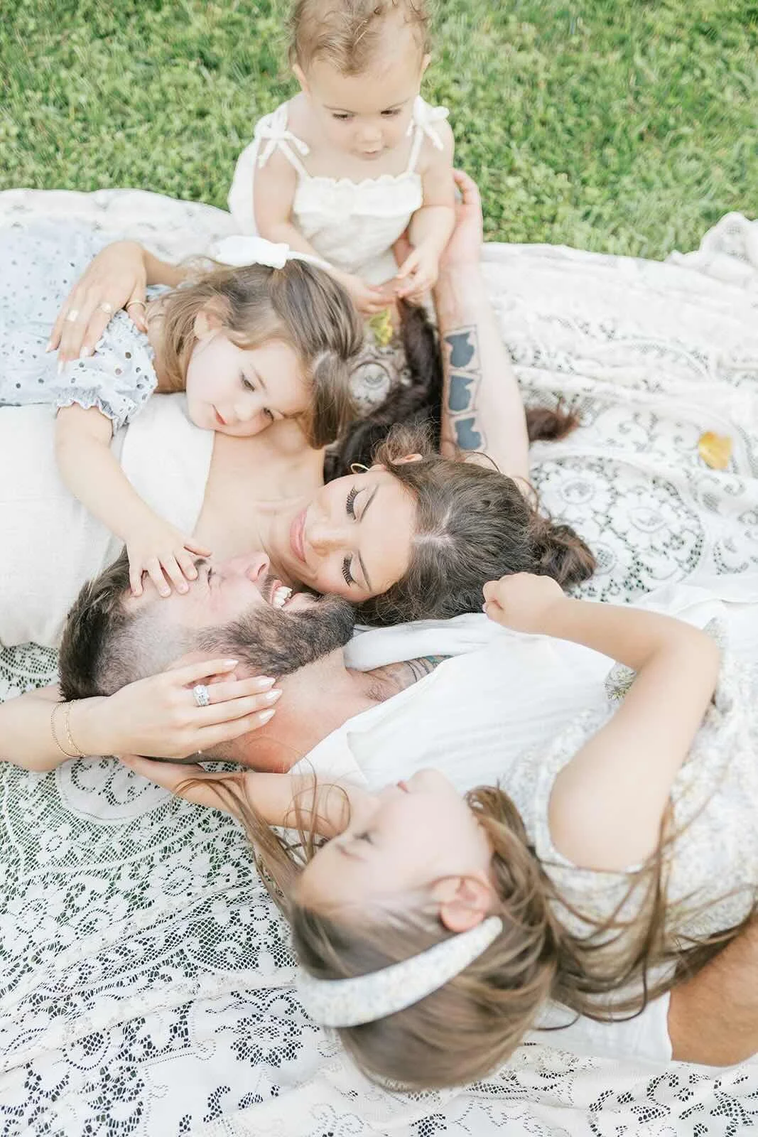 Family cuddling on a blanket outside - Raleigh Newborn Photographer