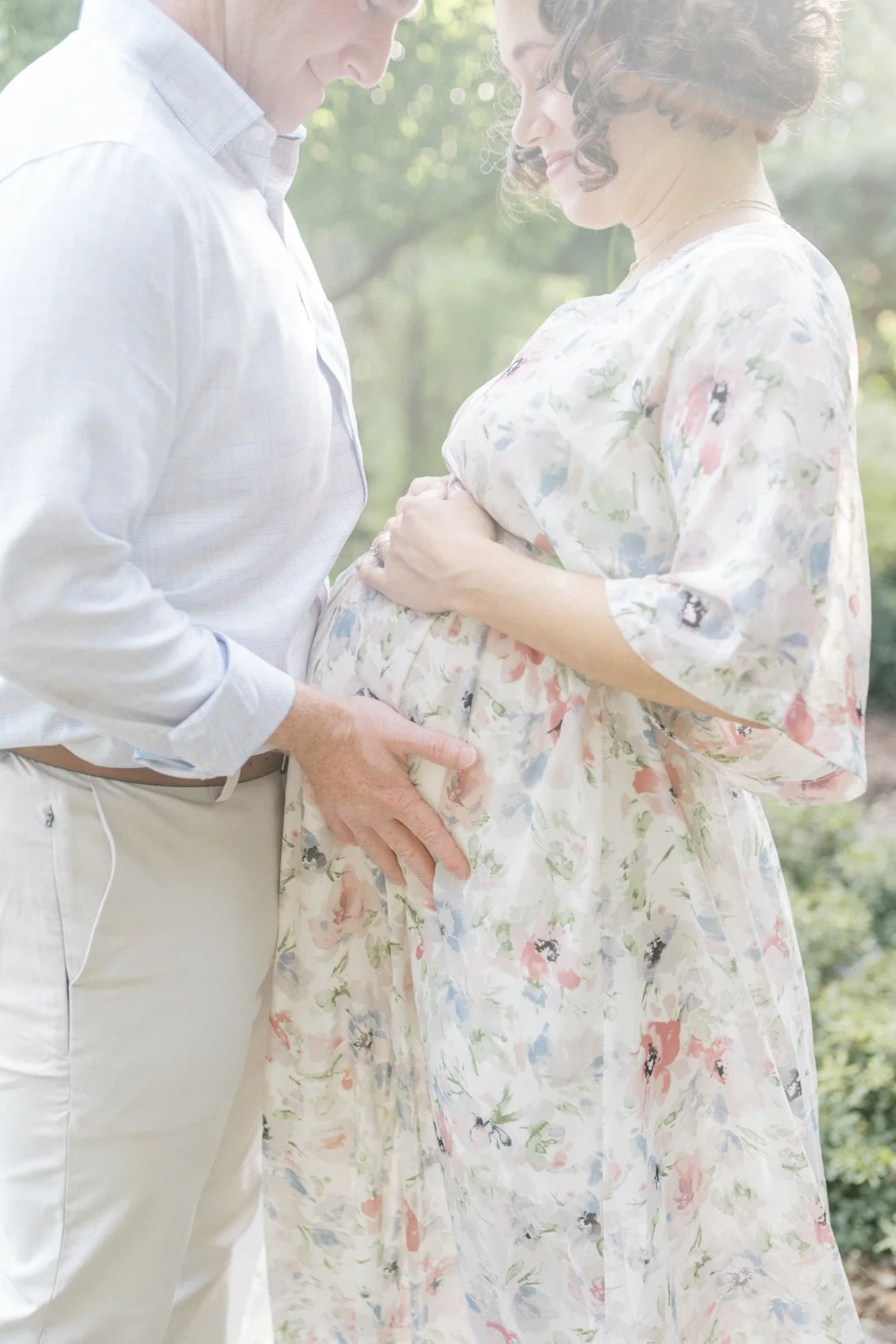 Expectant parents holding a baby bump during an outdoor maternity session, a meaningful idea for Mother’s Day photo gifts.