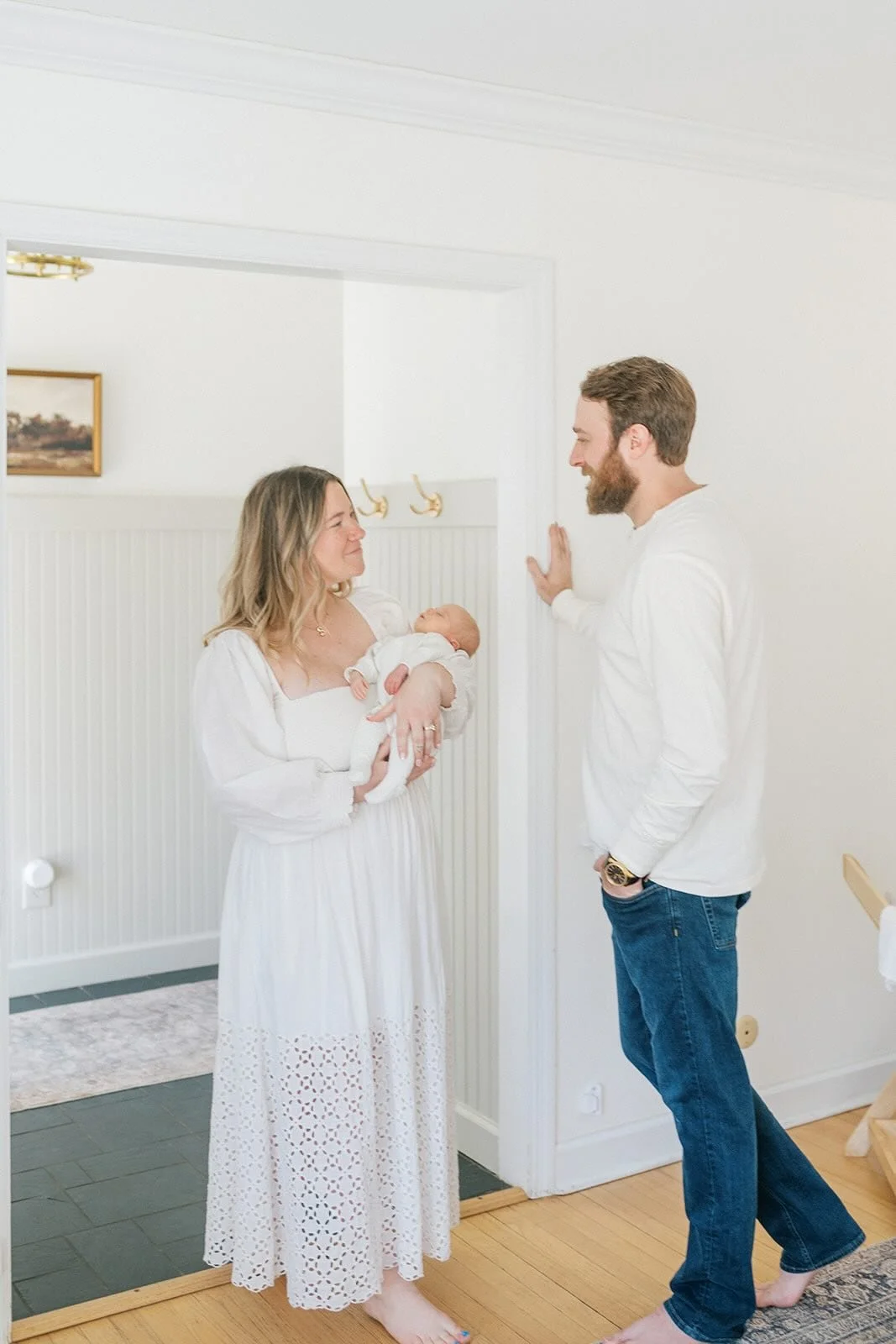 Mom holding baby while looking at Dad - Raleigh Newborn Photographer