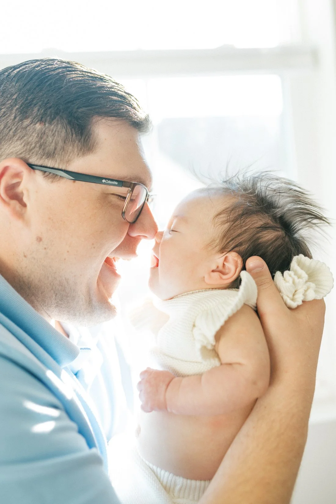 Dad nose to nose with his baby during a quiet moment of connection, showing the emotional depth of family photos through the years