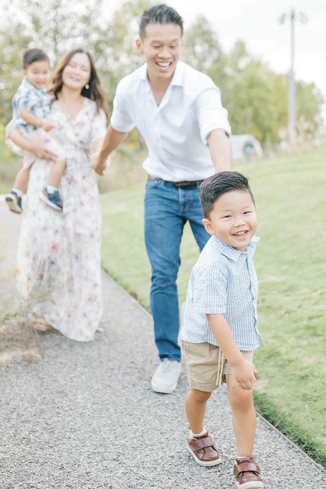 Family smiling while walking on the sidewalk - Raleigh Newborn Photographer