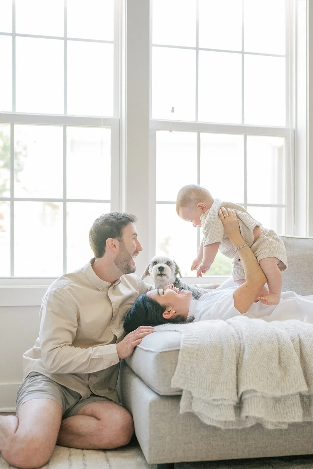 Mom holding baby while Dad looks on - Raleigh Newborn Photographer