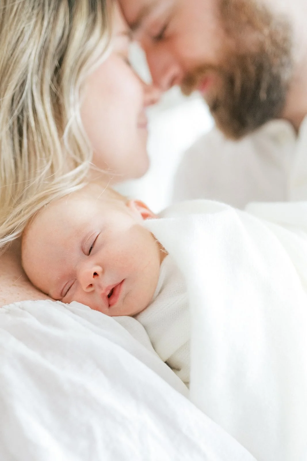 Mom holding baby while touching foreheads with Dad - Raleigh Newborn Photographer