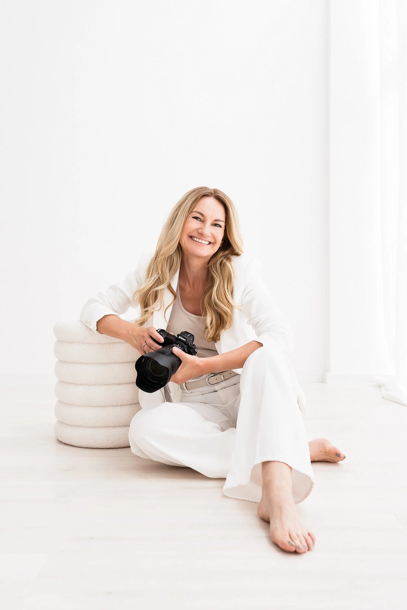 Tanja Pleis, brand photographer and embodied transformation coach, holding her camera