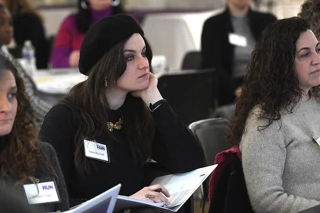 Photo of Ready to Run 2023 participants, seated and listening intently to off screen speakers