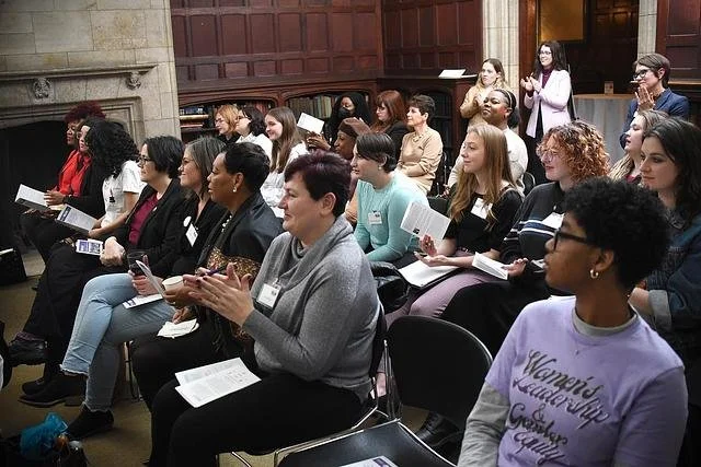 Photo of the Ready to Run participants, a group of women of varying races and ages, seated and standing, clapping
