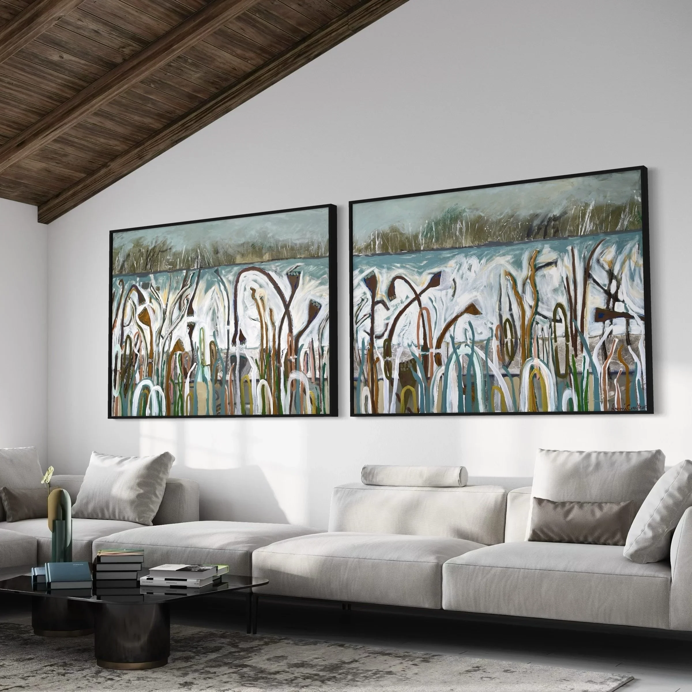 Modern living room with white sectional sofa, abstract paintings on the wall, black coffee table with books and decorative objects, and wooden ceiling beams.
