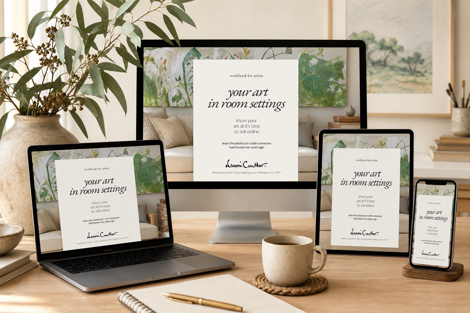 A workspace with a laptop, tablet, smartphone, and monitor displaying a workbook for artists titled 'Your Art in Room Settings,' surrounded by a plant, a cup, a notebook, and pens in a cozy, well-lit room.
