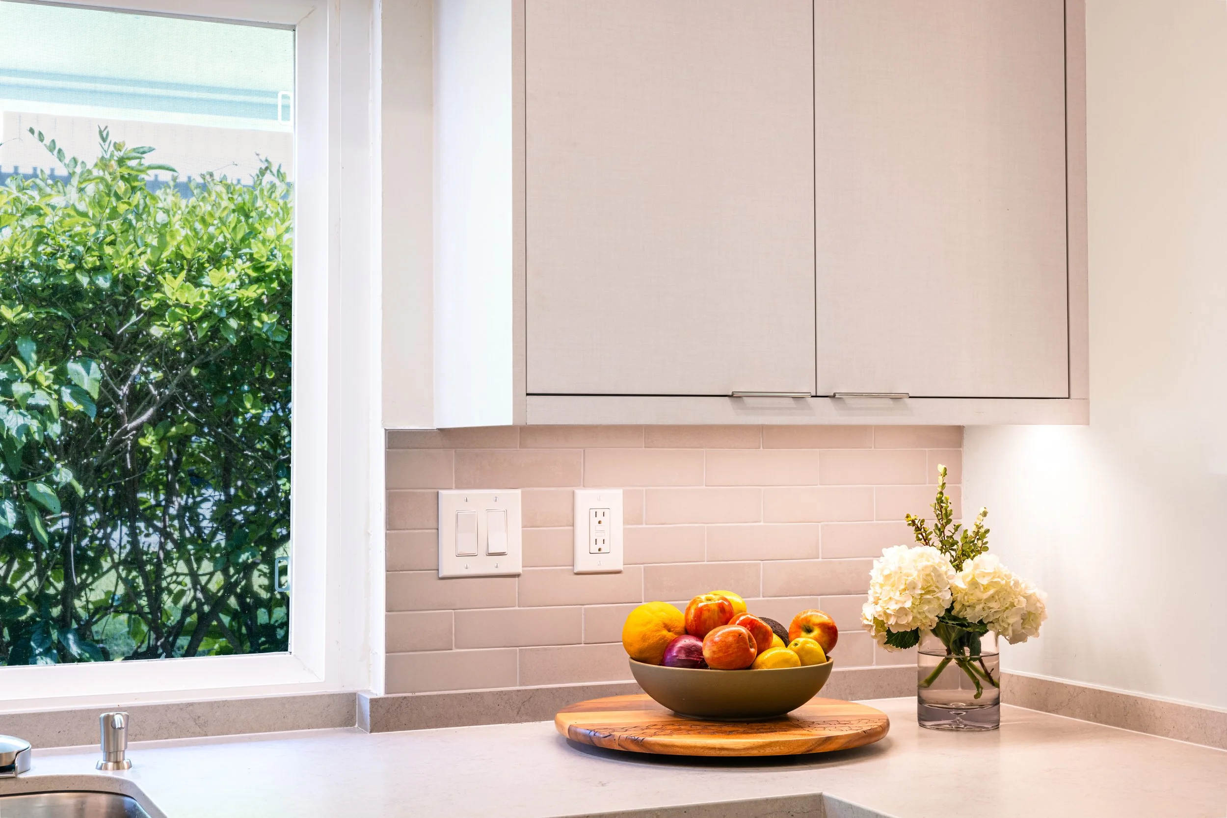 textured white upper cabinet with light grey countertop and tiled backsplash