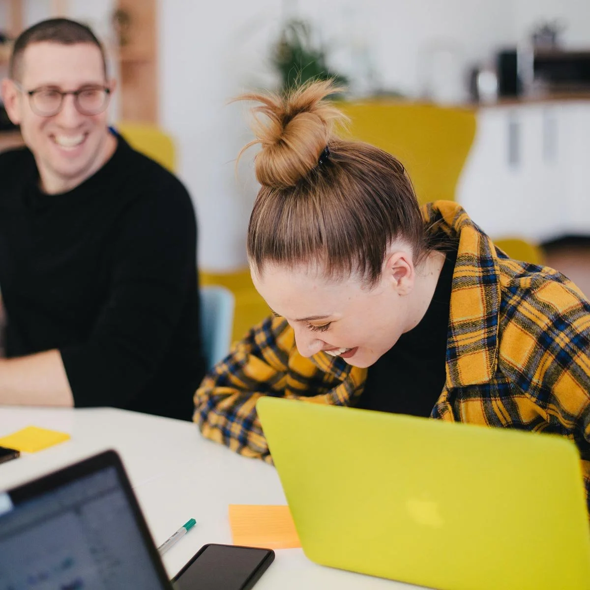 Red haired women in orange flannel shirt laughing.