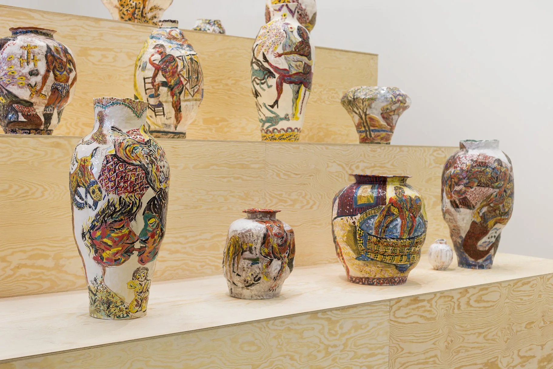 Colorful decorated ceramics displayed on wooden shelves.