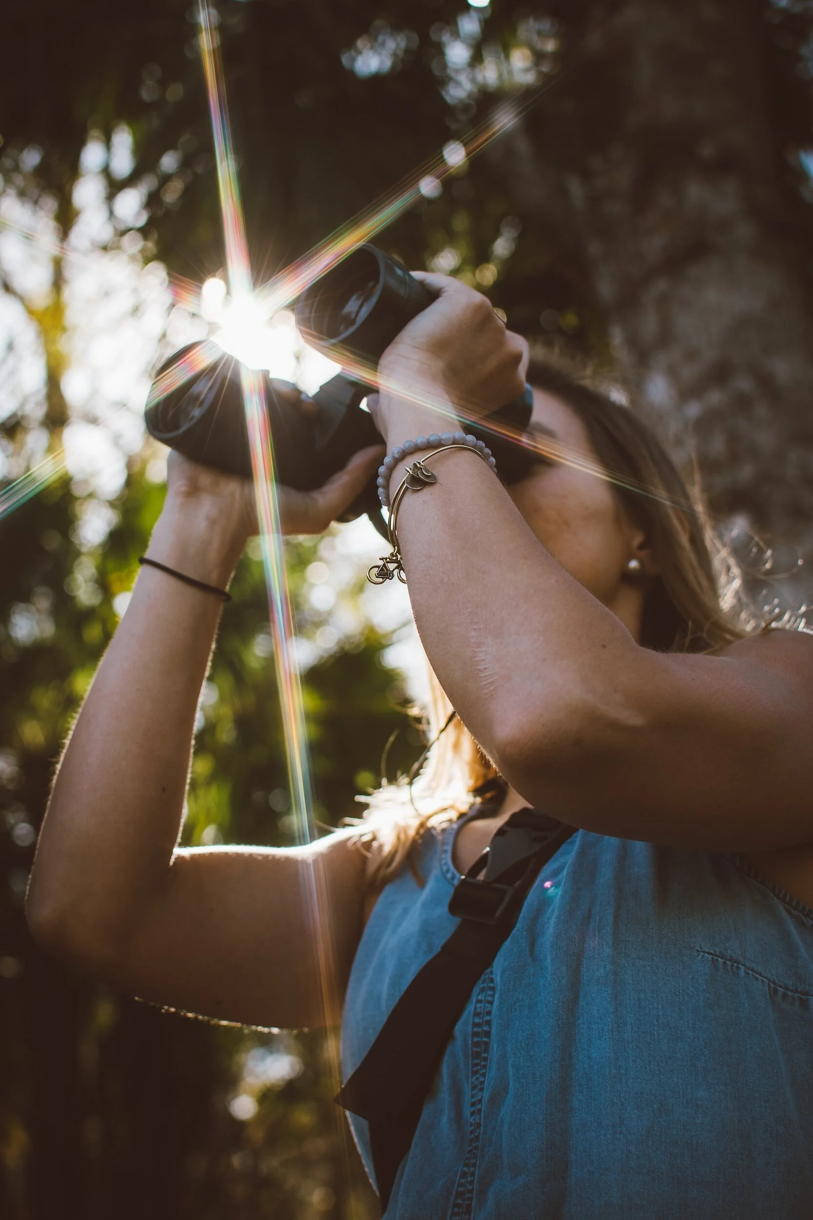 Woman looking through goggles in the woods
