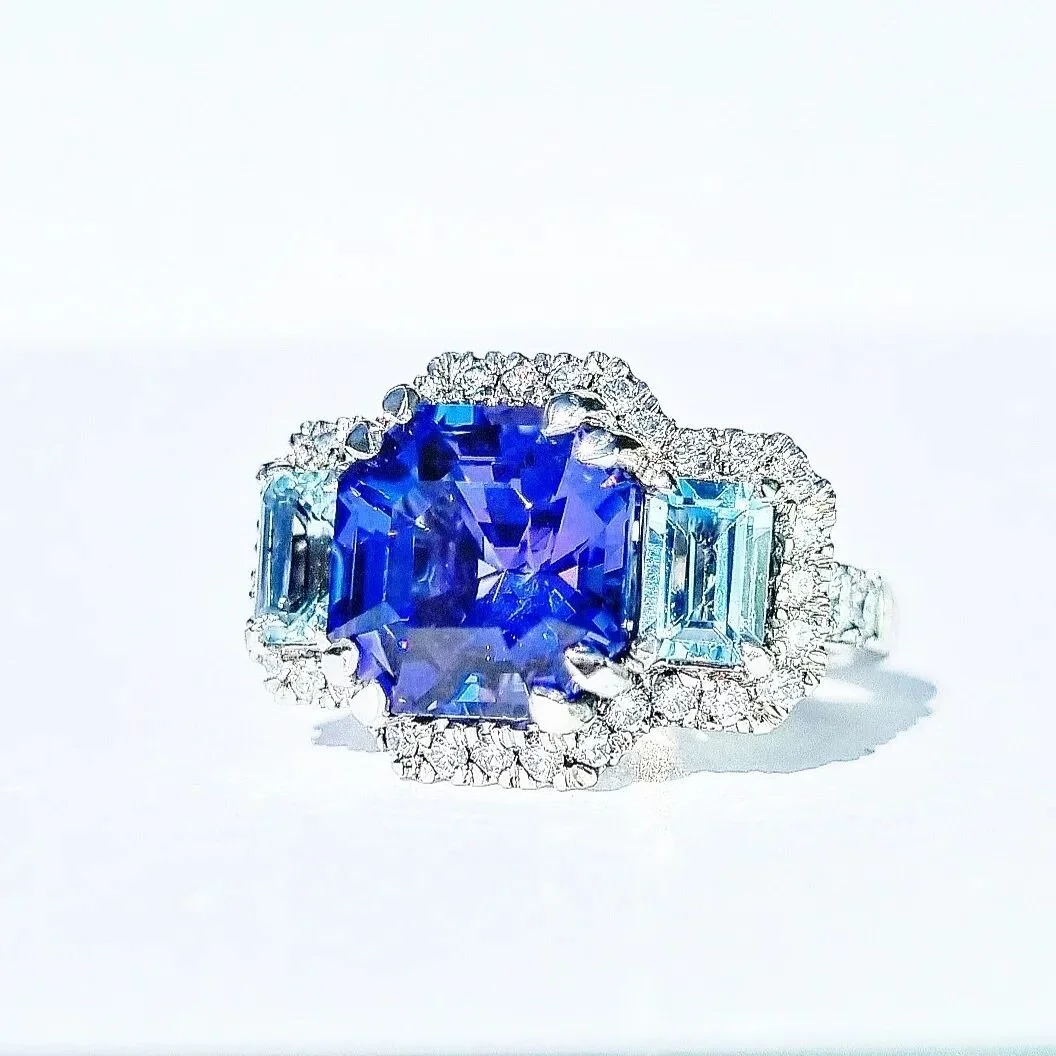 AVAILABLE! DM for details. this bold cocktail ring features 2 icey blue aquamarines that contrast perfectly to celebrate this hypnotic 5.4ct tanzanite that is a delicate balance of blue and violet. Surrounded by Dvs diamonds to frame the magic and ma