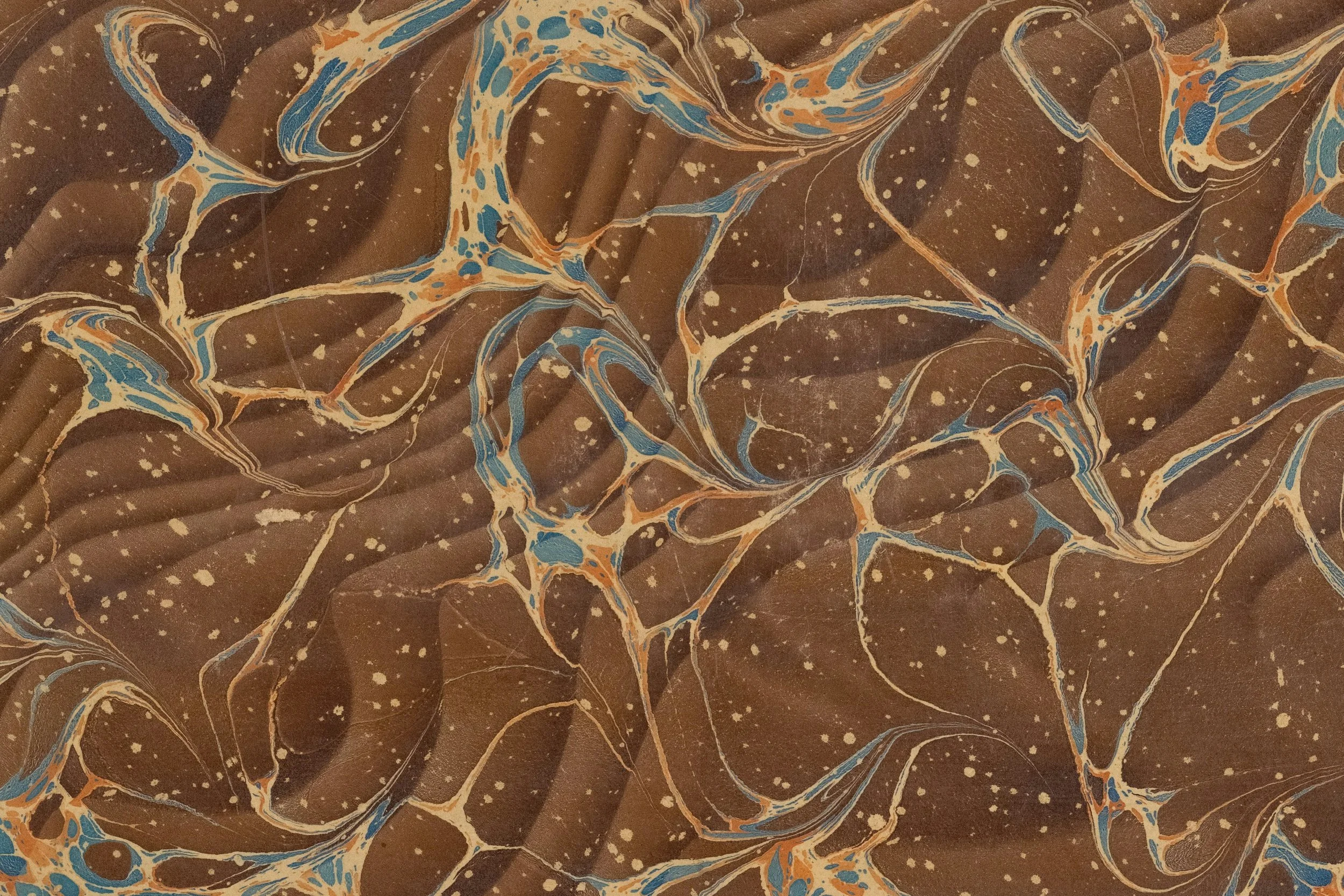 Close-up image of a marbled pattern with brown, blue, orange, and white swirls and speckles.