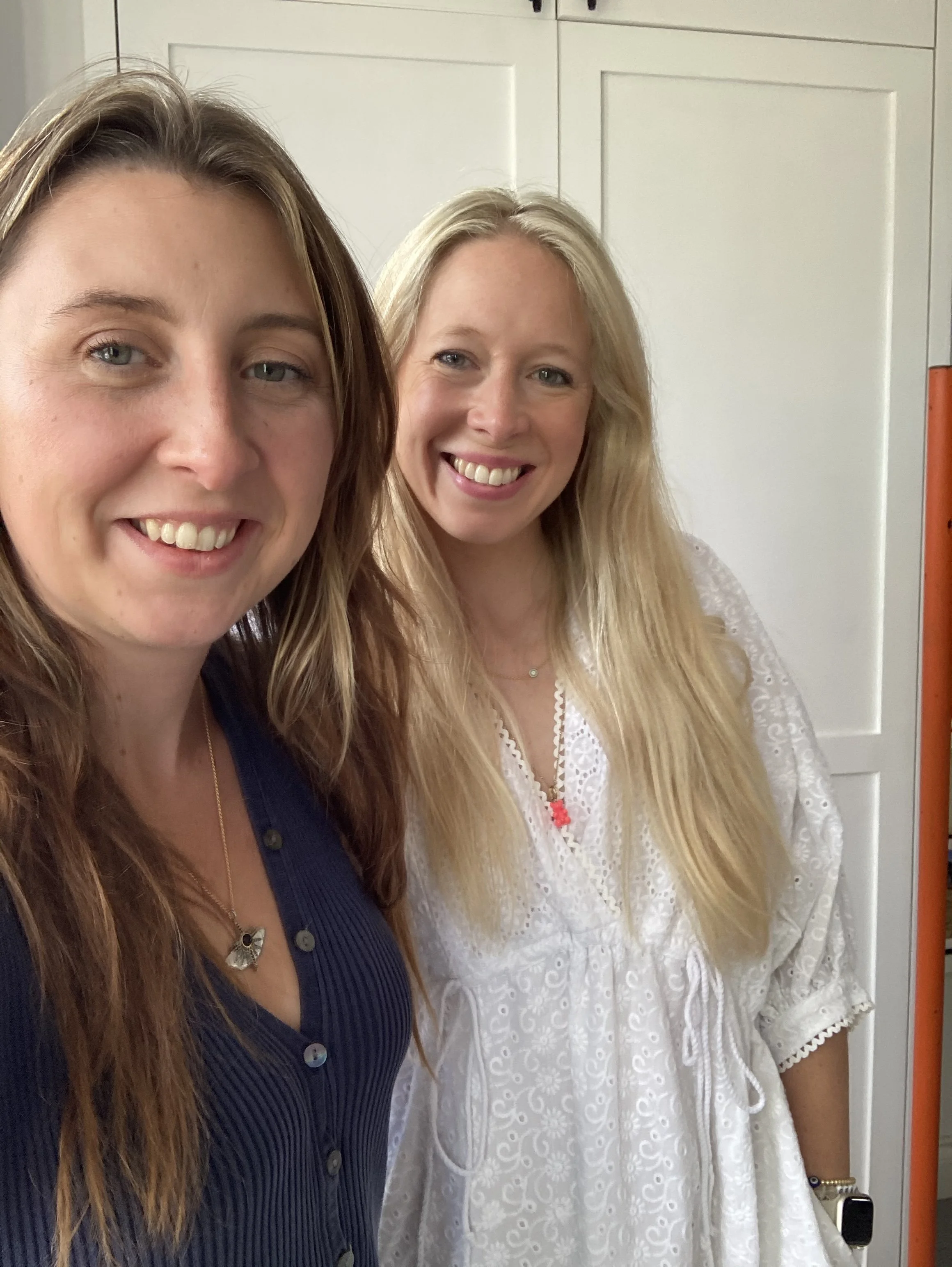Two women smiling pose for a photo.