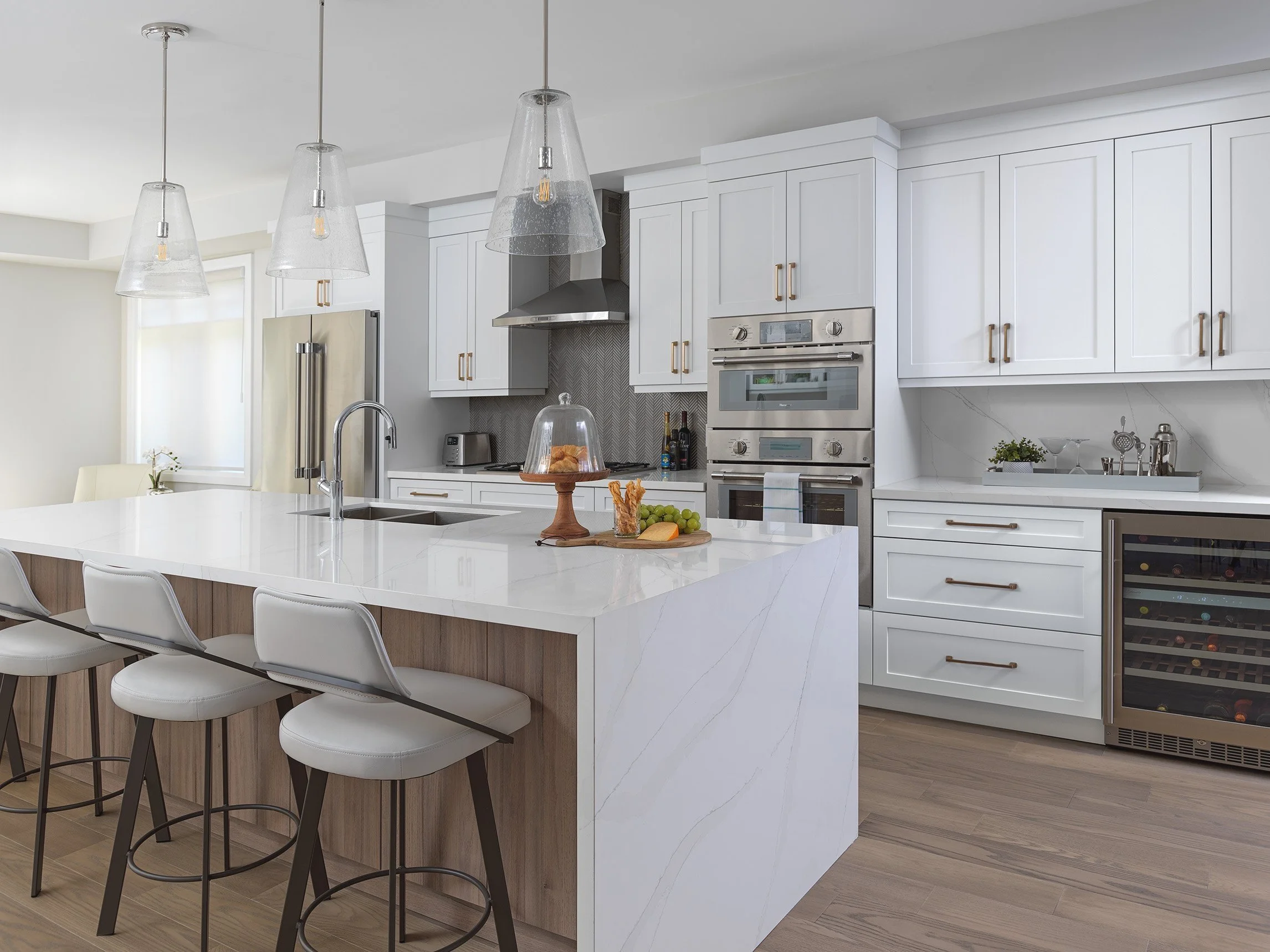 Modern kitchen with large island and stainless appliances in Compassway City Townhouse designed by Jackie Glass Inc.