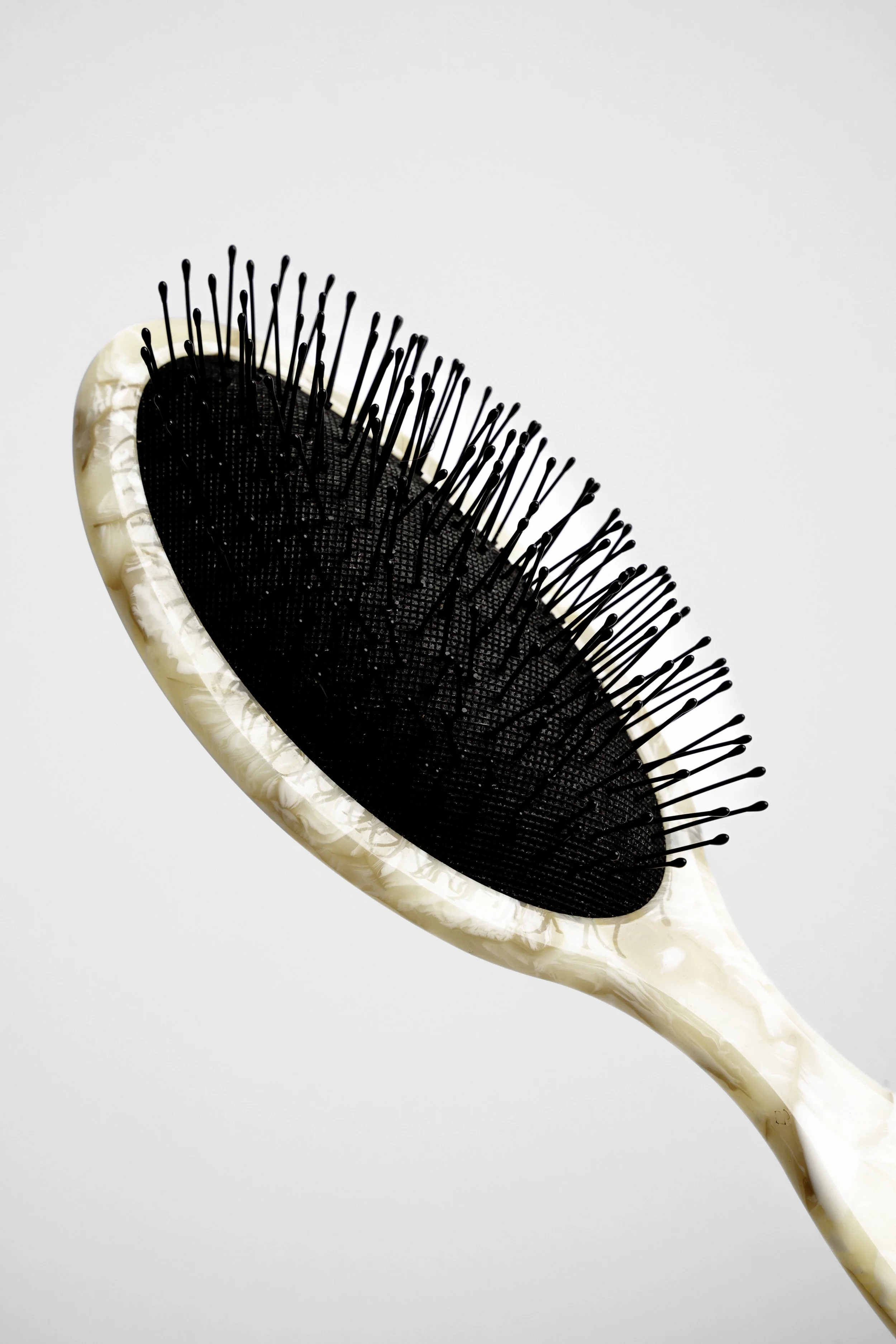 En hårbørste i en beige foran lys baggrund.