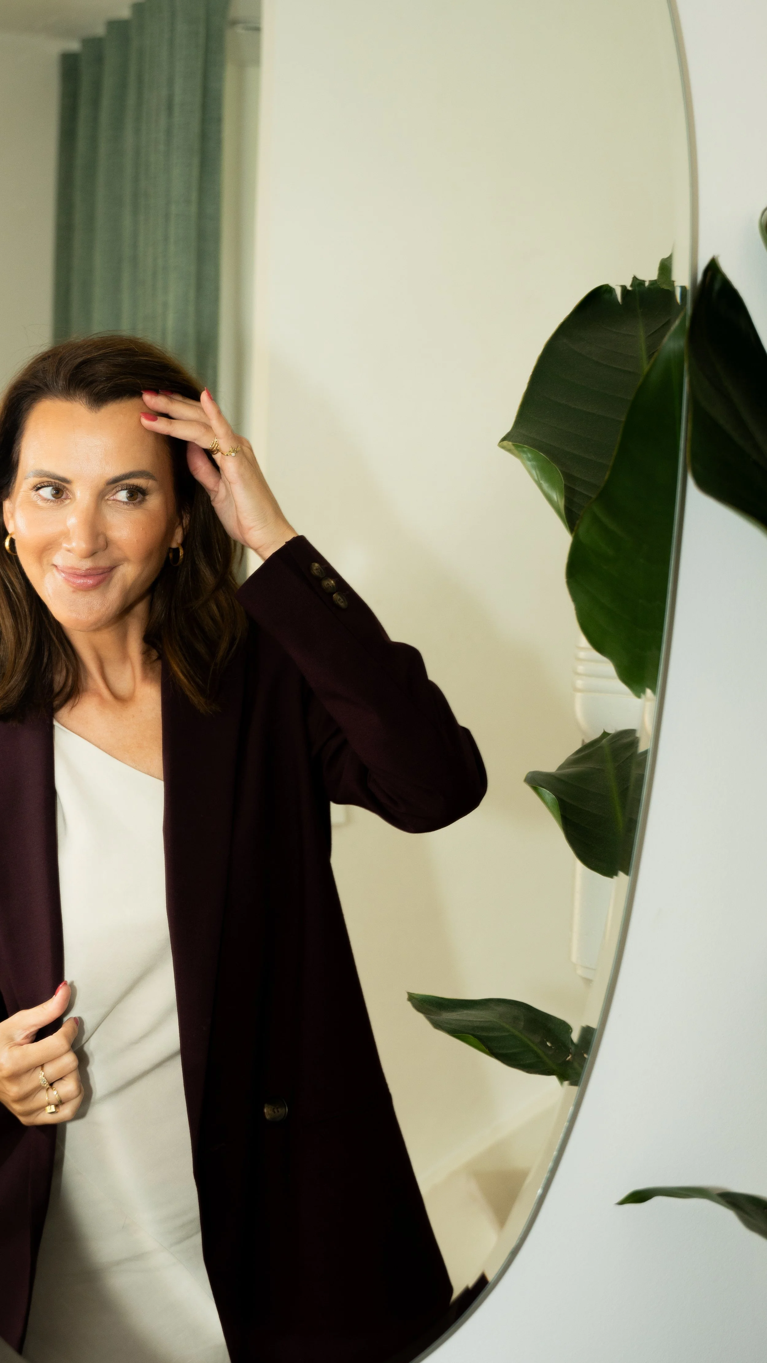 Kvindelig person ser i spejl, justerer sit hår.